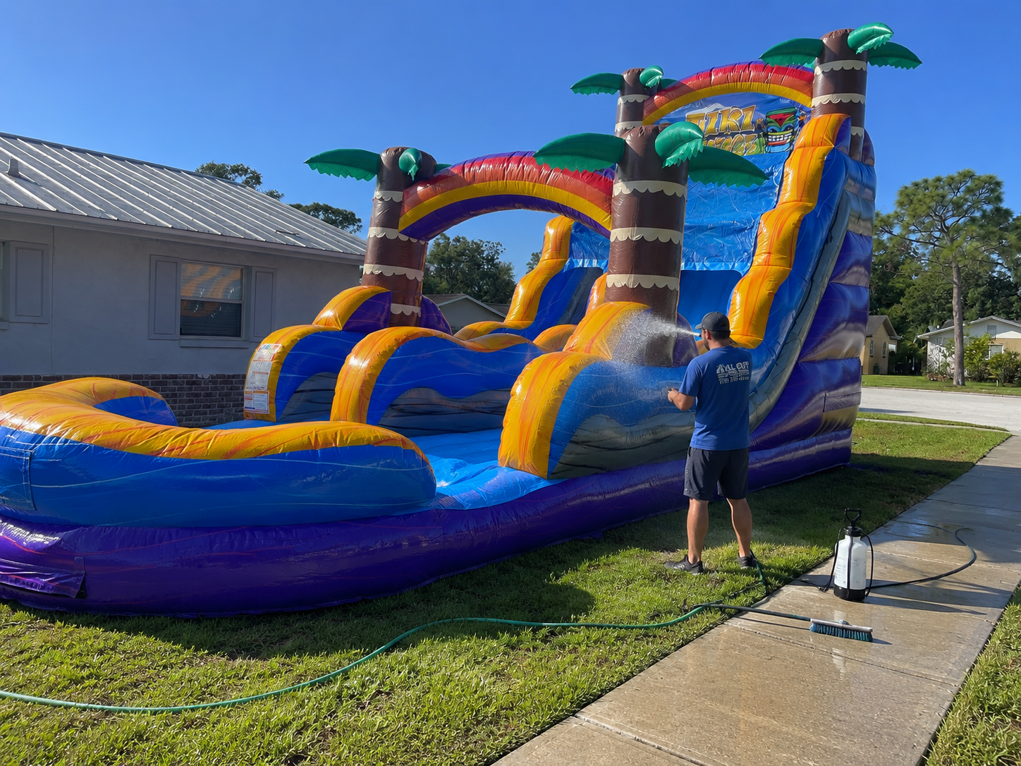 Crew cleaning and sanitizing an inflatable water slide before delivery